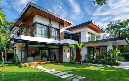 Modern two-story house with white walls, brown roof and black windows contemporary Bangkok home design, surrounded by lush green grass, palm trees, concrete walkways and garden lights