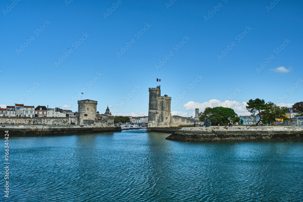 Port of La rochelle guarded by tour de la chaine and tour Saint Nicholas in the city center of downtown on a sunny day with clear blue sky, France