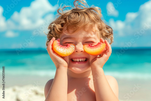 Happy child on the beach, laughing while covering his eyes with peach halves, summer vacation concept © ty