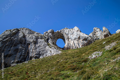 Ojo de Buey is an imposing natural rock arch located on one of the best-known peaks in the region: Peña Mea, located at 1,557 meters high. Aller, Asturias, Spain. photo