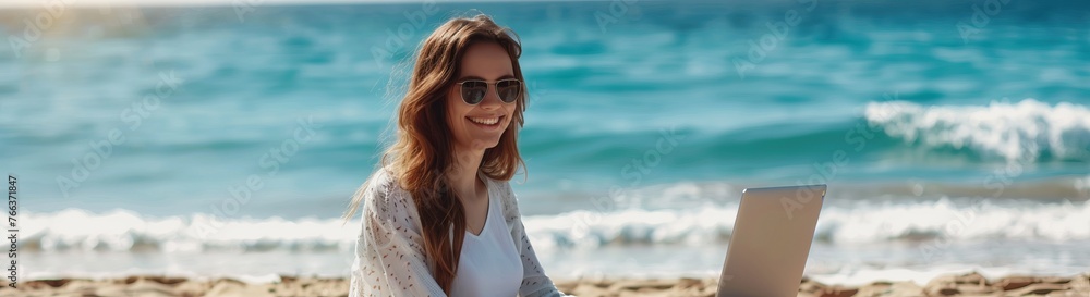 Happy female freelance worker sitting with a laptop on the seashore Happy female freelance worker sitting with a laptop on the seashore