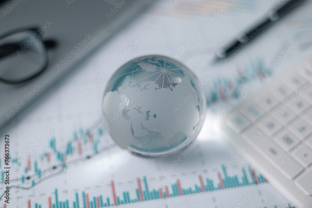 Stock market graphs and data with globe. Glass globe with stock charts, calculator and spectacles, Accounting Concept. Financial accounting stock market graphs analysis. Stock market graphs and data with globe. Glass globe with stock charts, calculator and spectacles, Accounting Concept. Financial accounting stock market graphs analysis.