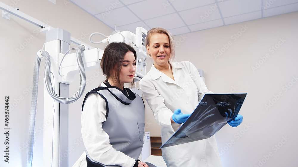 Fototapeta premium Patient consultation in a modern clinic against the background of x-ray equipment. Medical consultation, modern medical technologies.