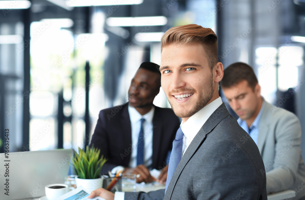Businessman with colleagues in the background in office. Businessman with colleagues in the background in office.