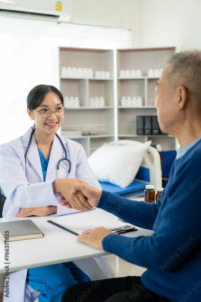 Old man shaking hands to greet a friendly Asian female doctor with a stethoscope around her neck shaking hands with a middle-aged male patient to reassure her in the hospital medical help Old man shaking hands to greet a friendly Asian female doctor with a stethoscope around her neck shaking hands with a middle-aged male patient to reassure her in the hospital medical help