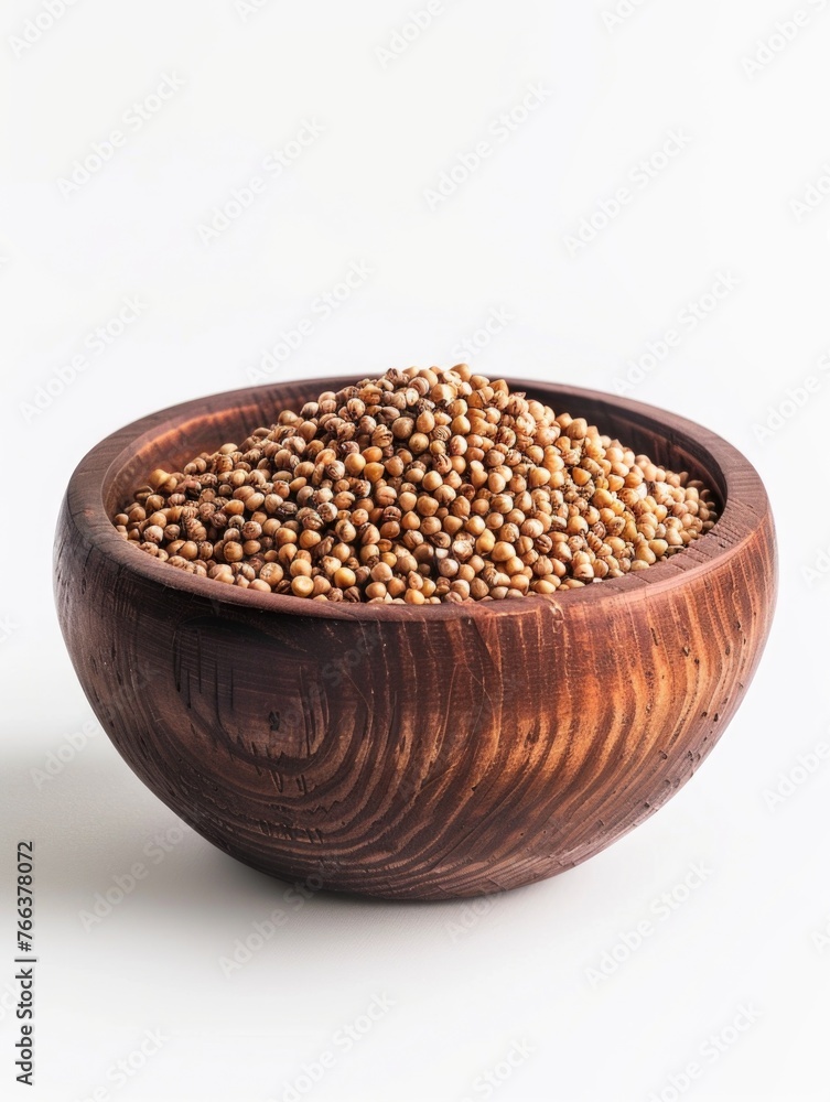 A bowl of seeds is sitting on a white background. The bowl is wooden and filled with a variety of seeds A bowl of seeds is sitting on a white background. The bowl is wooden and filled with a variety of seeds