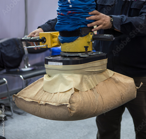 Worker use vacuum tube lifter moving sack.