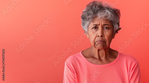 Expressive Face of Unhappy Senior Indian Female on Pink Background