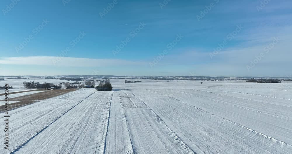 Krajobraz wiejski zimą z lotu ptaka, pola oraz niebieskie niebo w zimie pola pokryte śniegiem oraz cały krajobraz w białym kolorze Krajobraz wiejski zimą z lotu ptaka, pola oraz niebieskie niebo w zimie pola pokryte śniegiem oraz cały krajobraz w białym kolorze