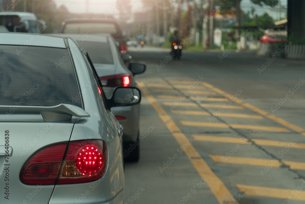 Rear side of car with turn on brake light. Traffic jam on the asphalt road with yellow line and bokeh light background.