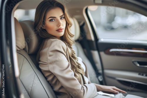 A business woman is sitting on the back seat of a luxury car © Igor