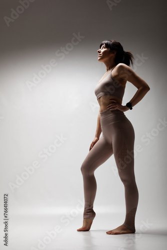 Beautiful caucasian woman in sports exercise outfit. Half silhouette shot of a confident girl standing