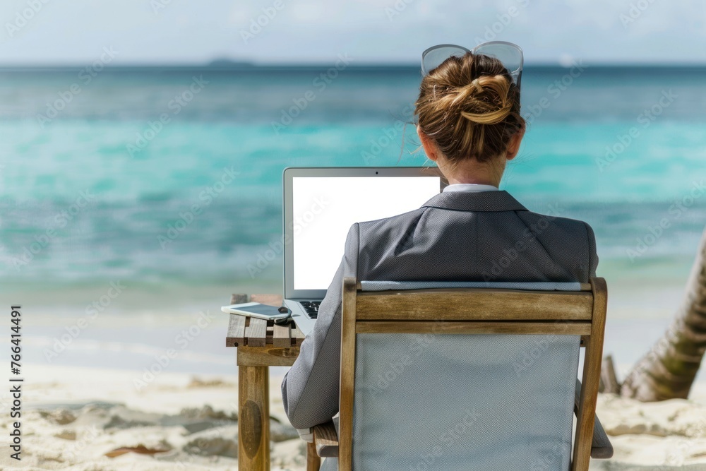 Mature businesswoman in suit working on computer on the beach