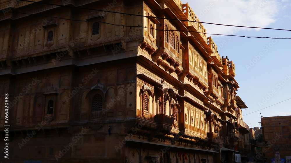 Balade et visite culturelle et touristique de la ville de Jaisalmer, en Inde, avec ses magnifiques façades de bâtiments aux murs chauds, sableux et de couleur jaune, jeu d'ombre et de lumière, environ