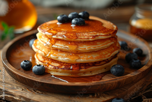 A stack of pancakes topped with fresh blueberries on a plate breakfast