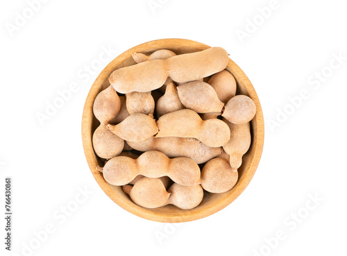 Tamarind fruit in wooden bowl isolated on white background, top view