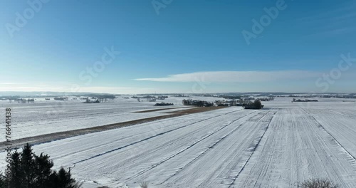 Krajobraz wiejski zimą z lotu ptaka, pola oraz niebieskie niebo w zimie pola pokryte śniegiem oraz cały krajobraz w białym kolorze photo