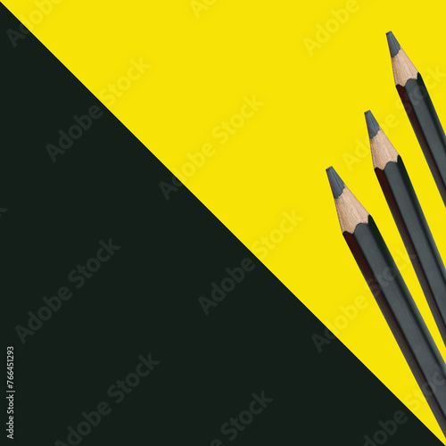 Black pencils on a yellow paper art board and have copy space.