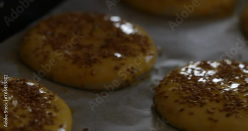 A gentle hand ensures each Qrashel is adorned with sesame seeds, adding a touch of elegance and enhancing their homemade charm