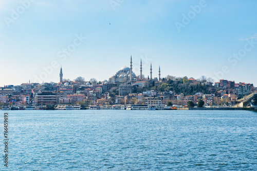 Istanbul, Turkey - March 23, 2024 - Beautiful view of the area of Eminönü in the Fatih district on the Golden Horn with Süleymaniye Mosque on a sunny day. This was on the first day of spring. photo