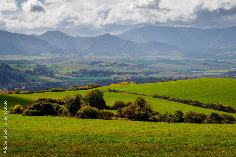 Mountain landscape. In the foreground, a farmland and autumn trees. In the distance you can see the Low Tatras Zilina Region. Beszeniowa. Slovakia.