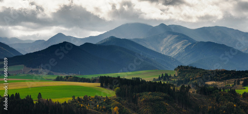 Mountain landscape. In the foreground, a farmland and autumn trees. In the distance you can see the Low Tatras Zilina Region. Beszeniowa. Slovakia.