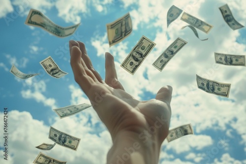 A Hand reaching out to catch falling dollar bills from the sky photo