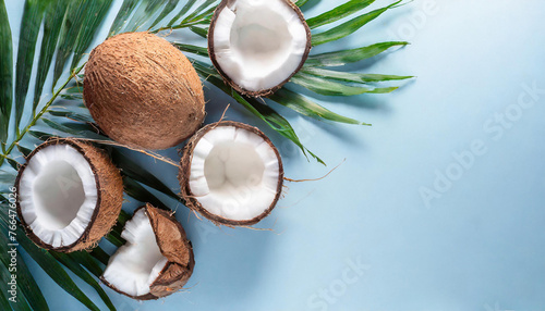 summer banner with coconuts on a light blue background. Top view, flat lay with a big copy space