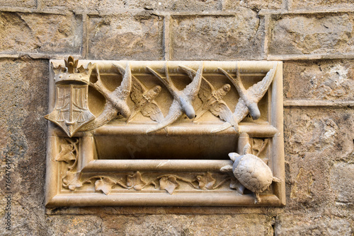 old mailbox facade made or marble with birds and a turtle in the gothic area of Barcelona, catalonia, spain