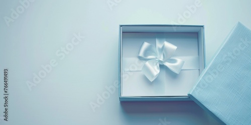 A white bow inside a blue gift box, perfect for gift wrapping ideas © Fotograf