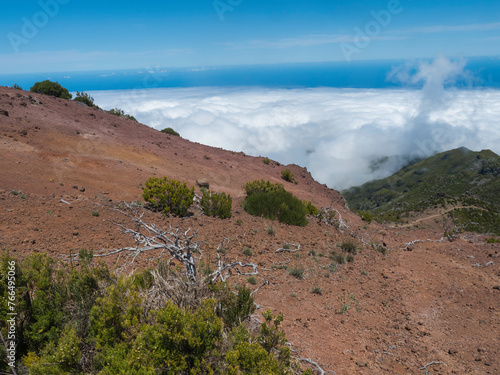 View from Pico Ruivo highest peak in the Madeira, Portugal. Green mountains, misty clouds and and atlantic ocean at Hiking trail PR1.2 from Achada do Teixeira to Pico Ruivo. © Kristyna