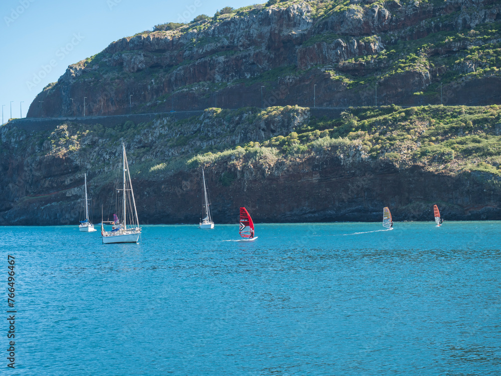 Fototapeta premium Sailing ships and yachts at Machico bay, Madeira, Portugal. Machico is popular resort town at east coast of Madeira Island with golden sand beach.