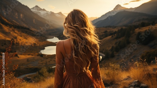 Blonde woman standing on a hill admiring the mountain and river view