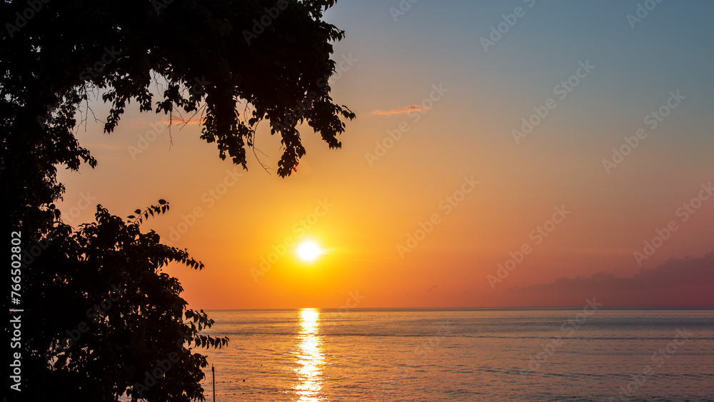 Summer sunset over the sea. Tree leaf silhouettes. Summer card or banner. Summer sunset over the sea. Tree leaf silhouettes. Summer card or banner.