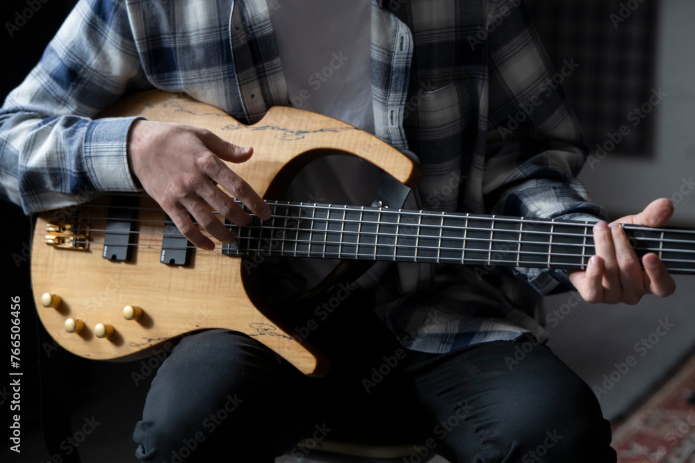 Close-Up View of a Musician Playing a Bass Guitar During an Indoor Session Close-Up View of a Musician Playing a Bass Guitar During an Indoor Session