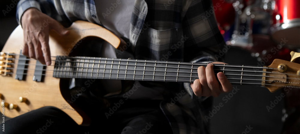 Close-Up View of a Musician Playing a Bass Guitar During an Indoor Session Close-Up View of a Musician Playing a Bass Guitar During an Indoor Session