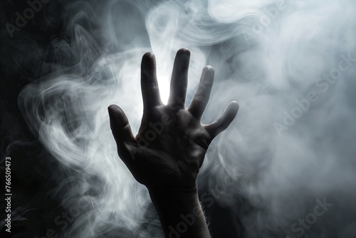 human hand in the smoke from the dark background