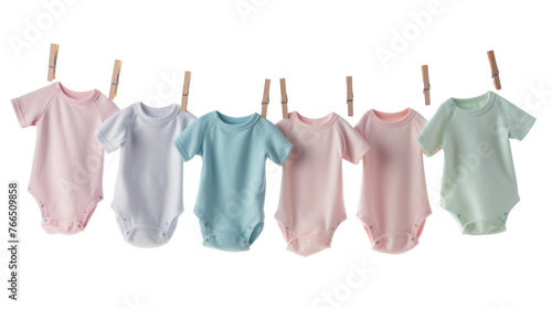Collection of colorful baby onesies hanging in a row on a clothesline