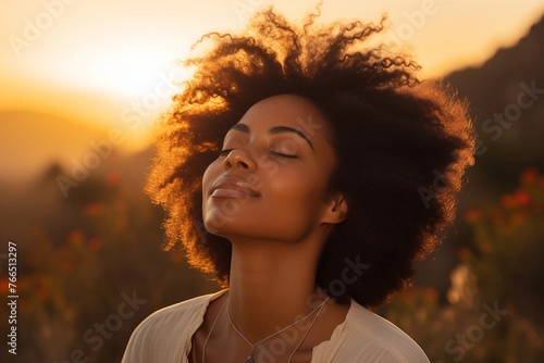 Retrato en primer plano de hermosa mujer negra respirando aire fresco durante un hermoso atardecer. Calma y relajación. photo