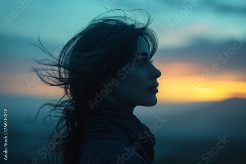 Woman Silhouetted Against Sky in Early Evening Twilight as the Wind Blows her Hair. Generative AI. 