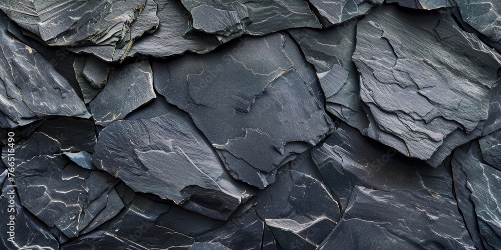 A close up of a rock wall with many different sized rocks. The rocks are all black and the wall is very rough. Scene is one of ruggedness and strength A close up of a rock wall with many different sized rocks. The rocks are all black and the wall is very rough. Scene is one of ruggedness and strength