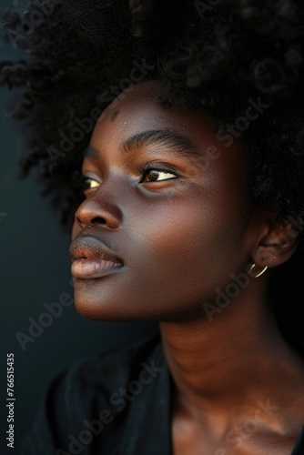 A woman with a dark complexion and a gold earring. She is looking at the camera. The image has a mood of confidence and self-assurance