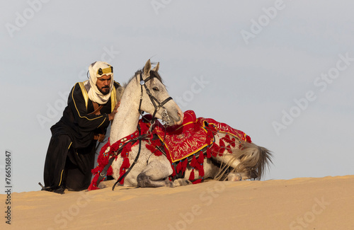 Saudi Man with his white stallion in a desert