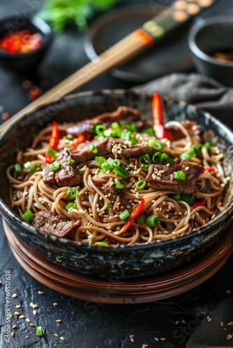 A bowl of noodles with meat and vegetables. The bowl is on a wooden plate