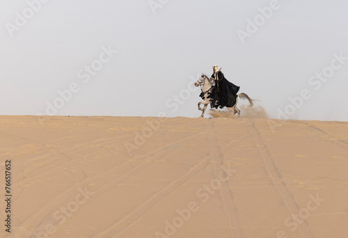 Saudi Man with his white stallion in a desert