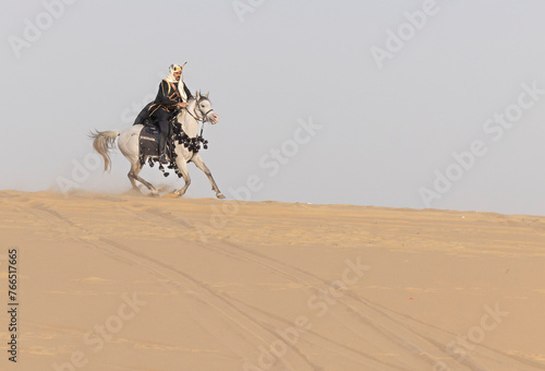 Saudi Man with his white stallion in a desert