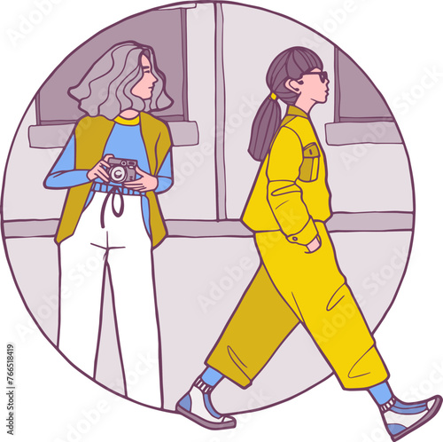 Une femme avec un appareil photo et une femme qui marche de profil avec une combinaison pantalon et des baskets