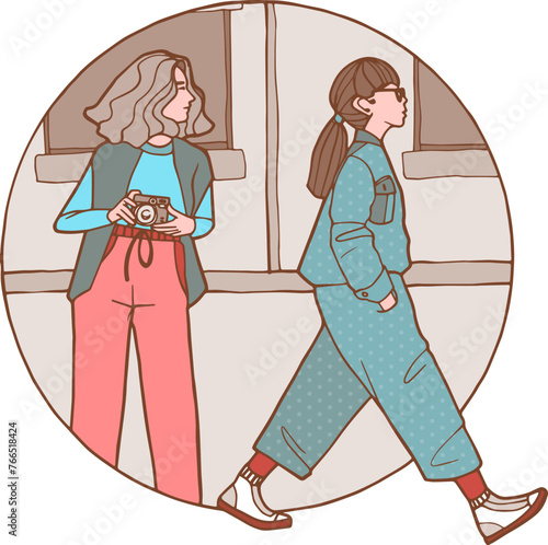 Une femme avec un appareil photo et une femme qui marche de profil avec une combinaison pantalon et des baskets