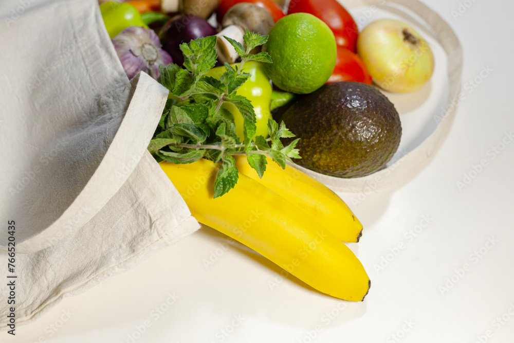 Grocery shopping concept and zero waste concept. Fresh vegetables and fruits in an reusable eco cotton bag. Close-up, top view, copy space.