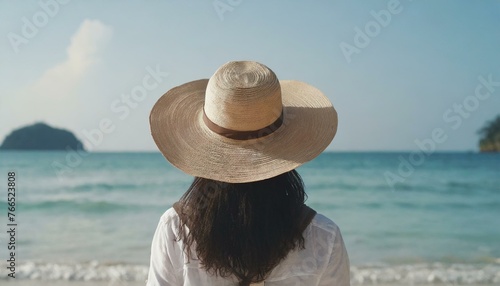  Traveller woman in hat looking on tropical beach, rear view. Female person enjoy sea vacation